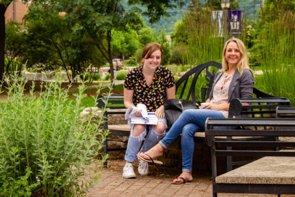 Two female student site on bench together on the WSU campus.